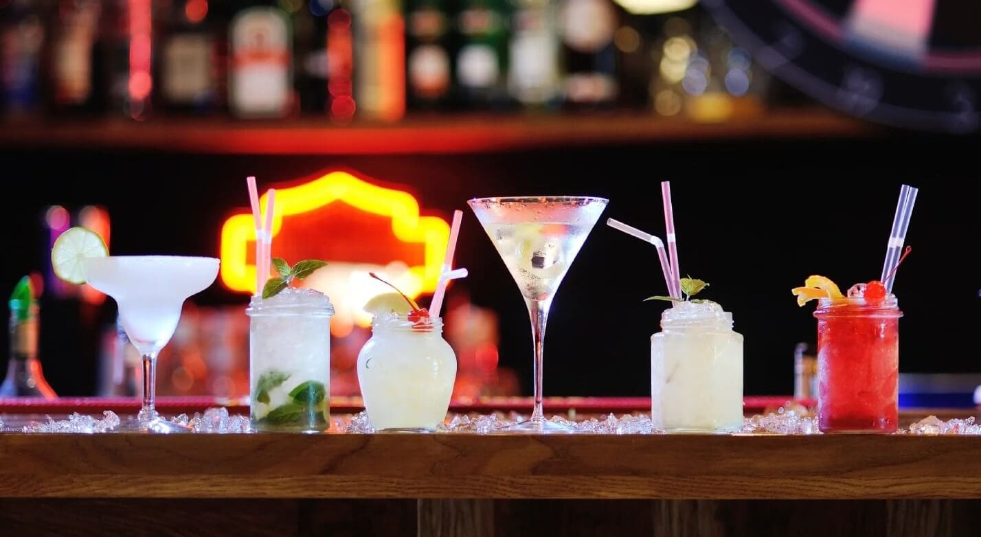 A bar with three different drinks on the counter.