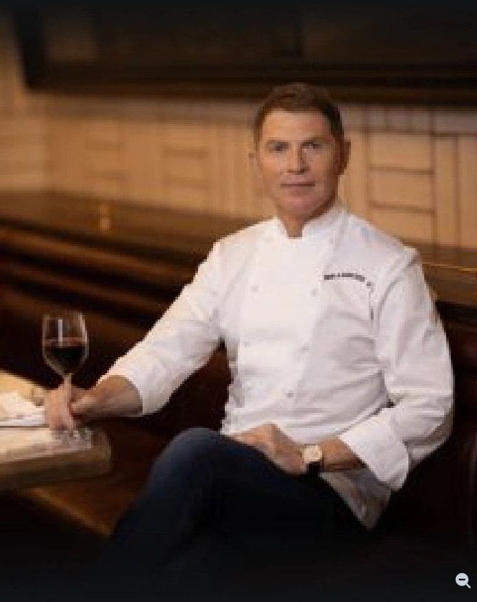 A man sitting at a table with a glass of wine.