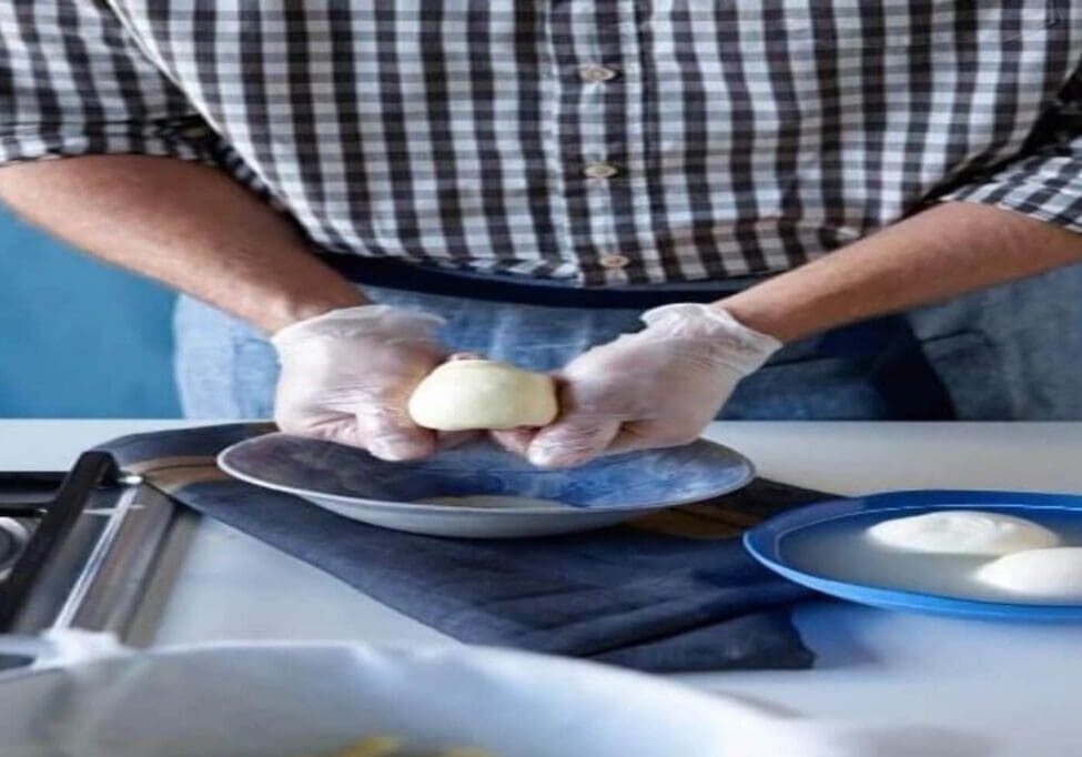 A person is peeling an apple on a plate.