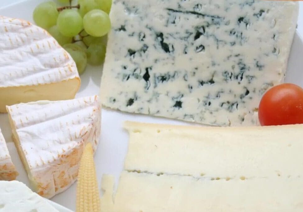 A close up of some cheese and grapes