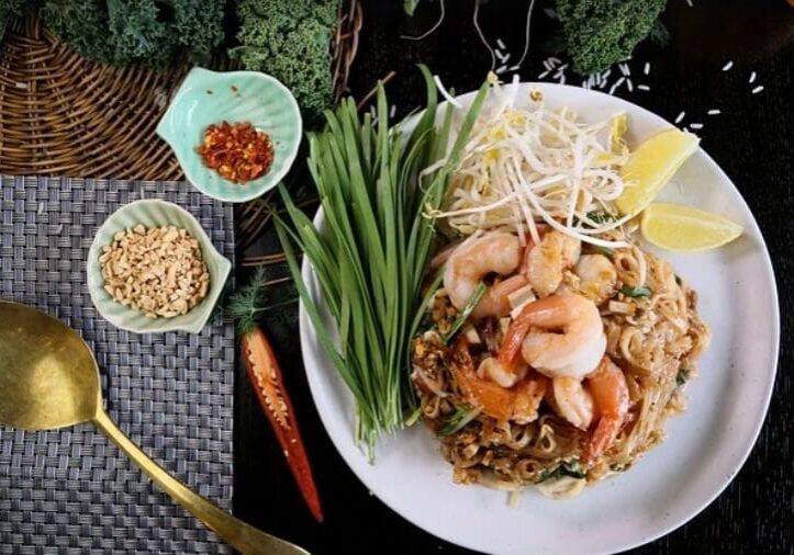 A plate of food on the table with vegetables and noodles.