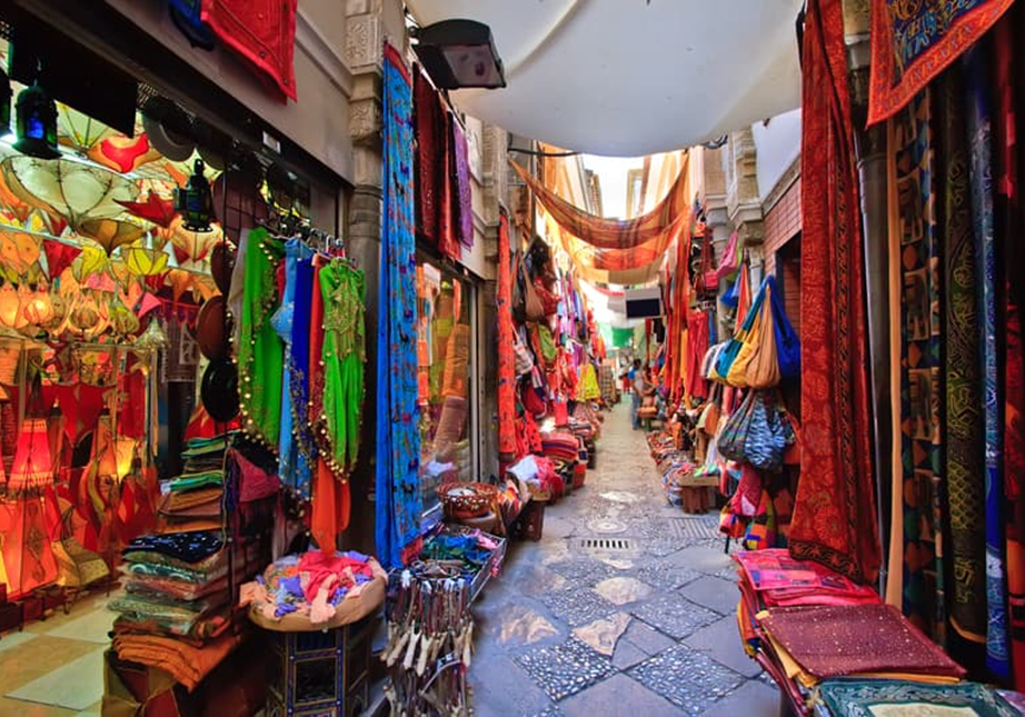 A market with many different colored fabrics and rugs.